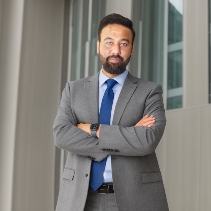 Ahmed Abdullah in a gray suit and blue tie
